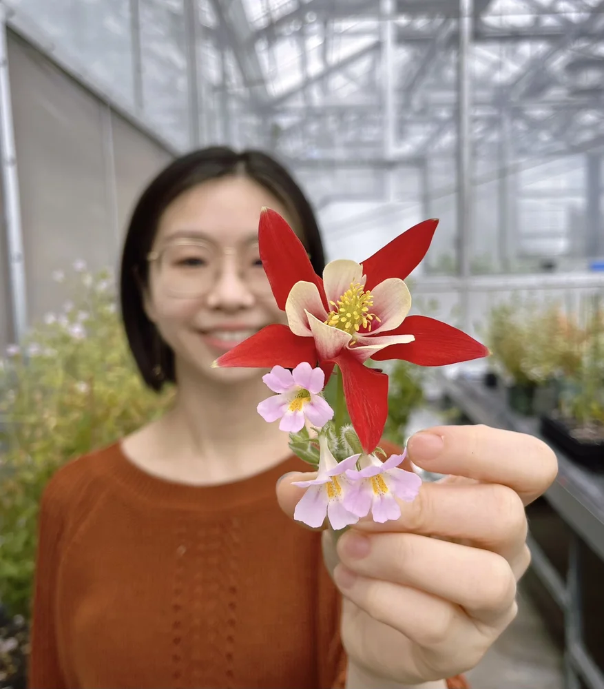 a woman holding a flower in front of her face