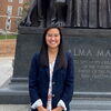 smiling woman in front of alma mater