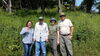 four smiling people in a field