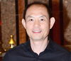 a man smiling in a blue button down shirt