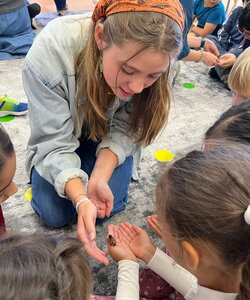A woman showing kids a cockroach