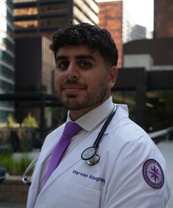 A man in a doctor's coat standing outside