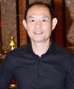 A smiling main in a blue button down shirt