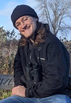 A photo of Mac Chamberlain sitting on a bench outside