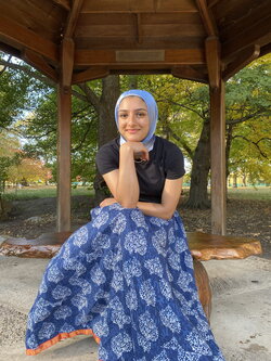 A photo of Mariam Vaid sitting under a gazebo