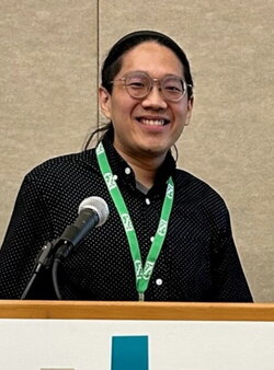 A photo of Sean Ooi standing at a podium