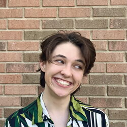 A photo of Anna Grimes standing in front of a brick wall
