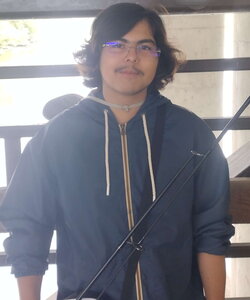 A photo of Angel Perez in a hoodie holding a fishing pole