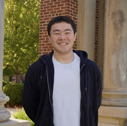 A photo of Drew Kim in front of a building