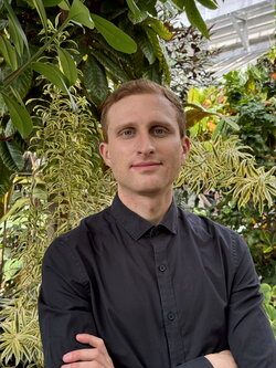 A photo of Bram Osterhout standing with plants behind him