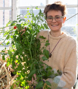 A photo of Erinn Dady holding a tomato plant