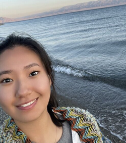 A photo of Minxing Zhu standing by the ocean