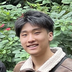 A photo of Samuel Cho standing in front of some plants