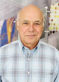 A photo of a bald man in a plaid button up shirt