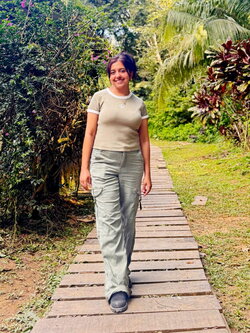 A smiling woman standing outside on a wooden land bridge